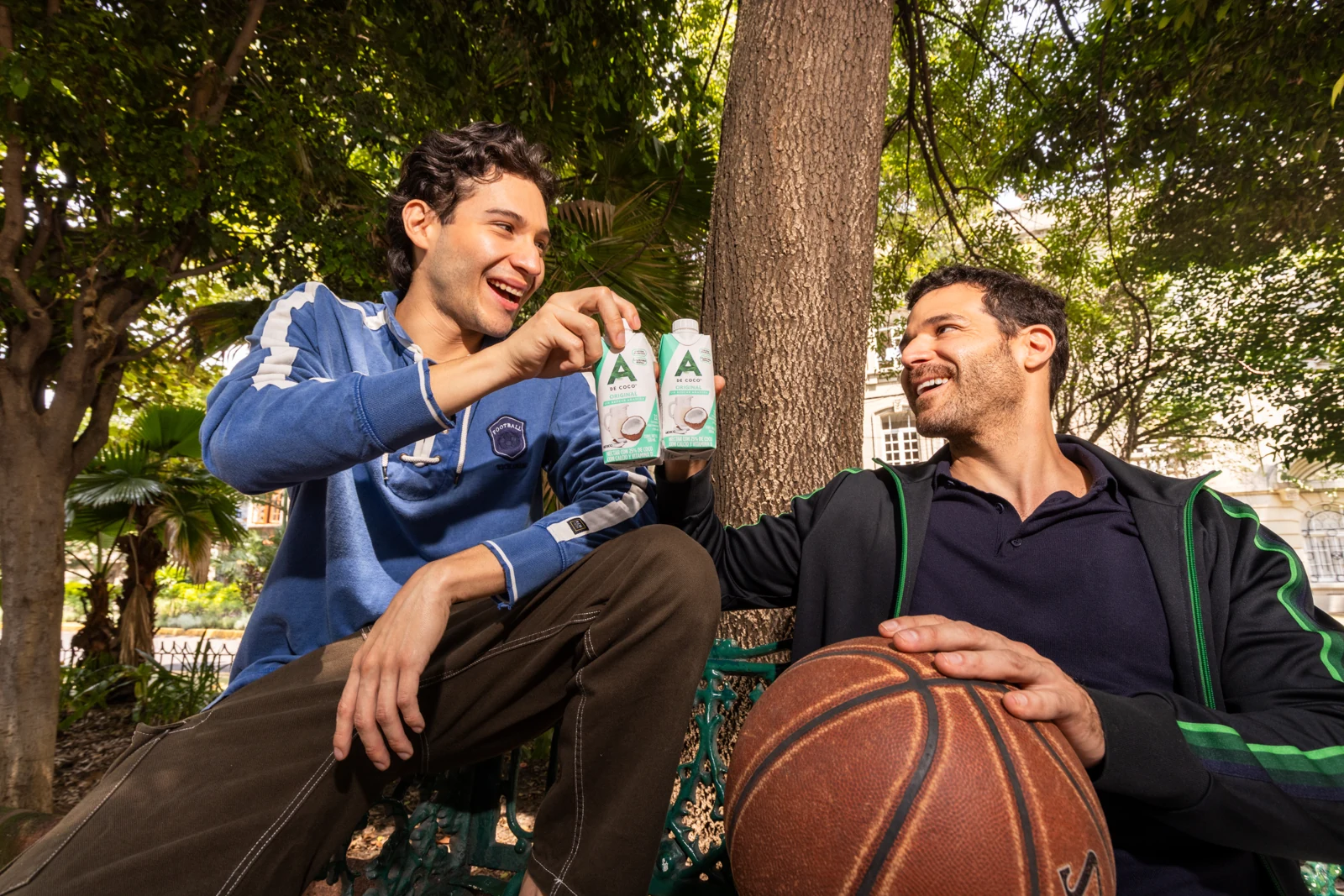 Dos amigos disfrutan néctar A de Coco después de jugar básquetbol